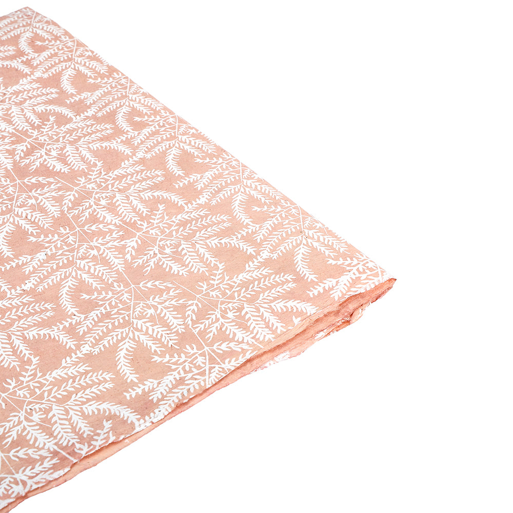 Gefalteter pfirsichfarbener ☆ Stoff mit weißem Blättermuster, dargestellt auf weißem Untergrund - ideal für kreative Geschenke Verpacken oder in Kombination mit nachhaltigem Papier für einen umweltfreundlichen Touch.