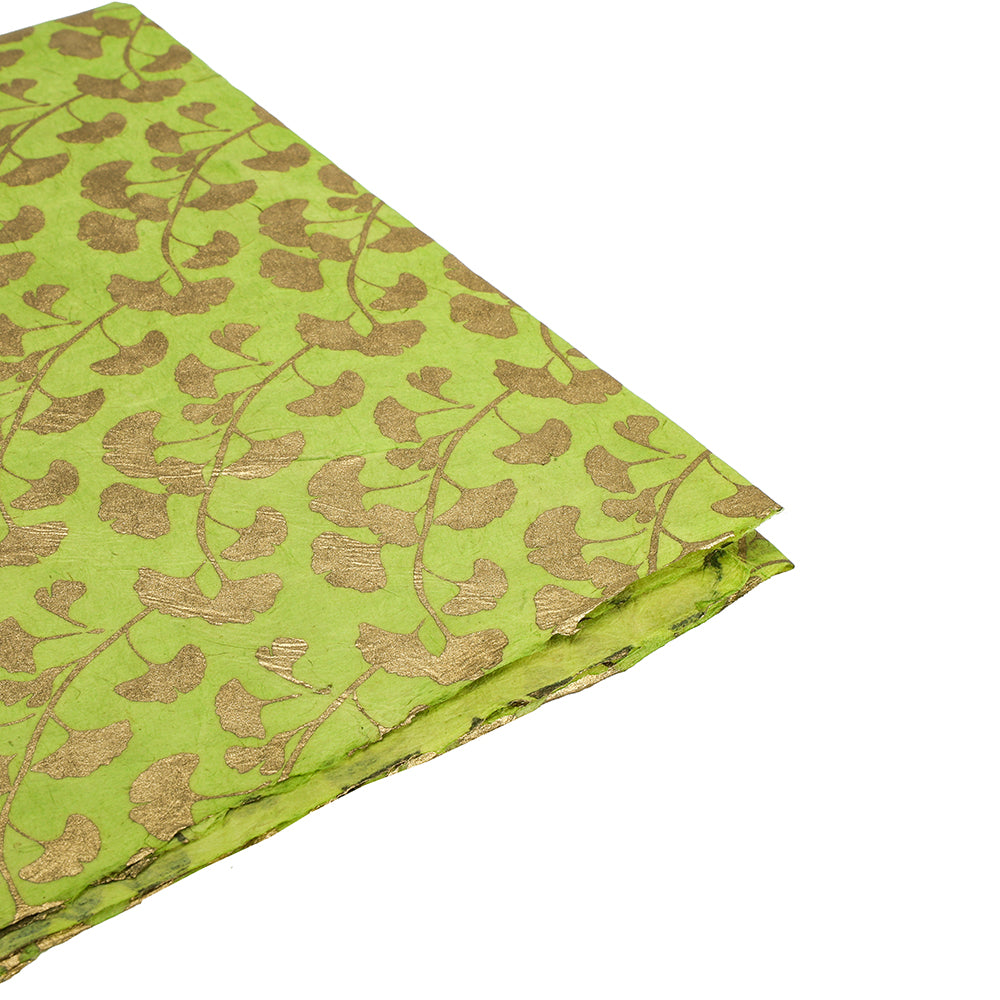 Grünes Nepalpapier von ☆ mit Blattgoldmuster, leicht gefaltet auf weißem Hintergrund - ideales nachhaltiges Papier für Geschenkpapier.