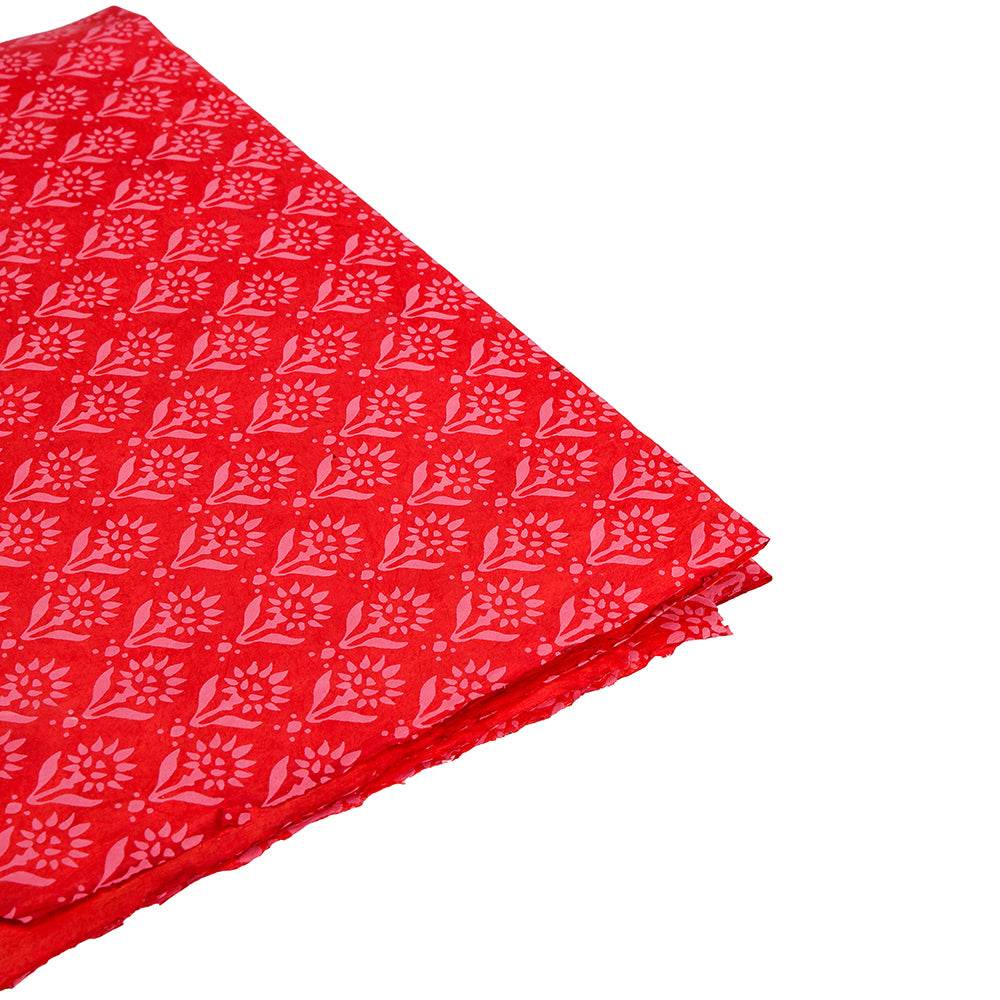 Fein säuberlich gefalteter roter Stoff mit rosa Blumenmuster von ☆, perfekt als einzigartige Geschenkverpackung oder zusammen mit Nepalpapier für eine nachhaltige, schöne Präsentation.