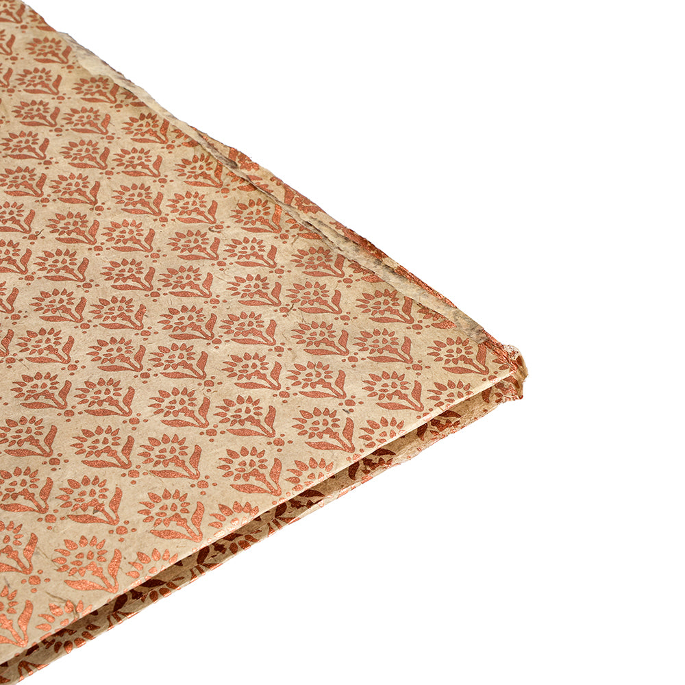 Gefalteter beiger Stoff mit einem sich wiederholenden orangefarbenen floralen Blockdruckmuster auf weißem Hintergrund - ein stilvoller ☆ Fund, ideal für Nepalpapier oder nachhaltige Geschenkverpackungen.