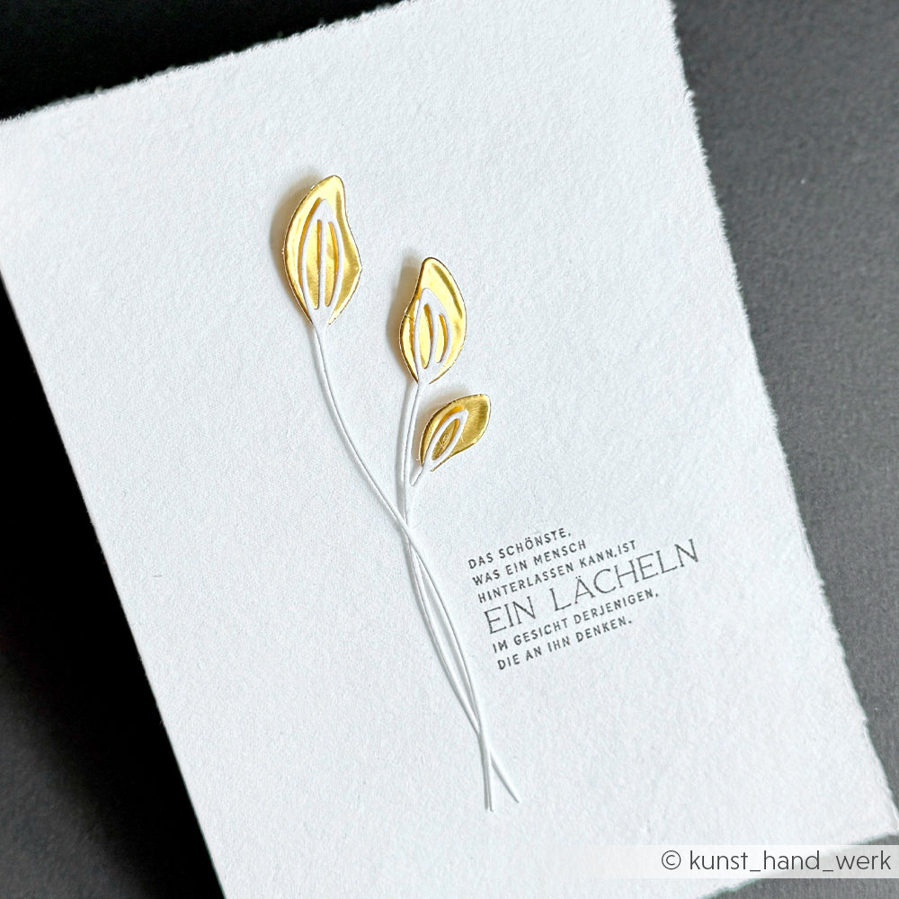 Minimalistische Karte von Alexandra Renke mit zwei Blattgoldmotiven und deutschem Text auf weißem Strukturpapier, veredelt mit Goldfolienakzenten - perfekt für kreative Bastelprojekte.