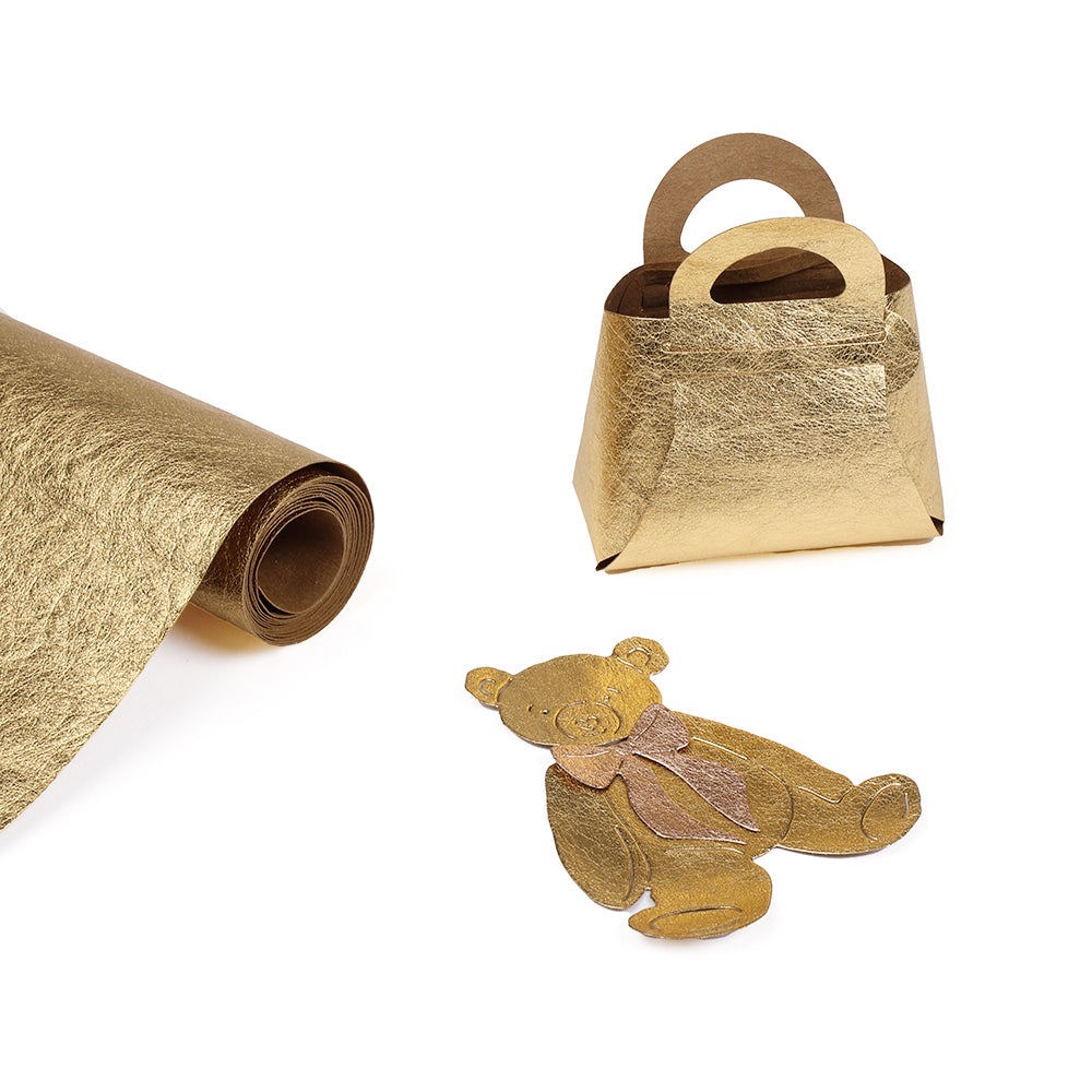 Eine Rolle seidenmatt glänzendes Papier, eine goldene Geschenktüte und ein goldener Teddybärausschnitt mit Schleife von Alexandra Renke - ideal für Buchbinder Material oder kreative PAPPaper Projekte.