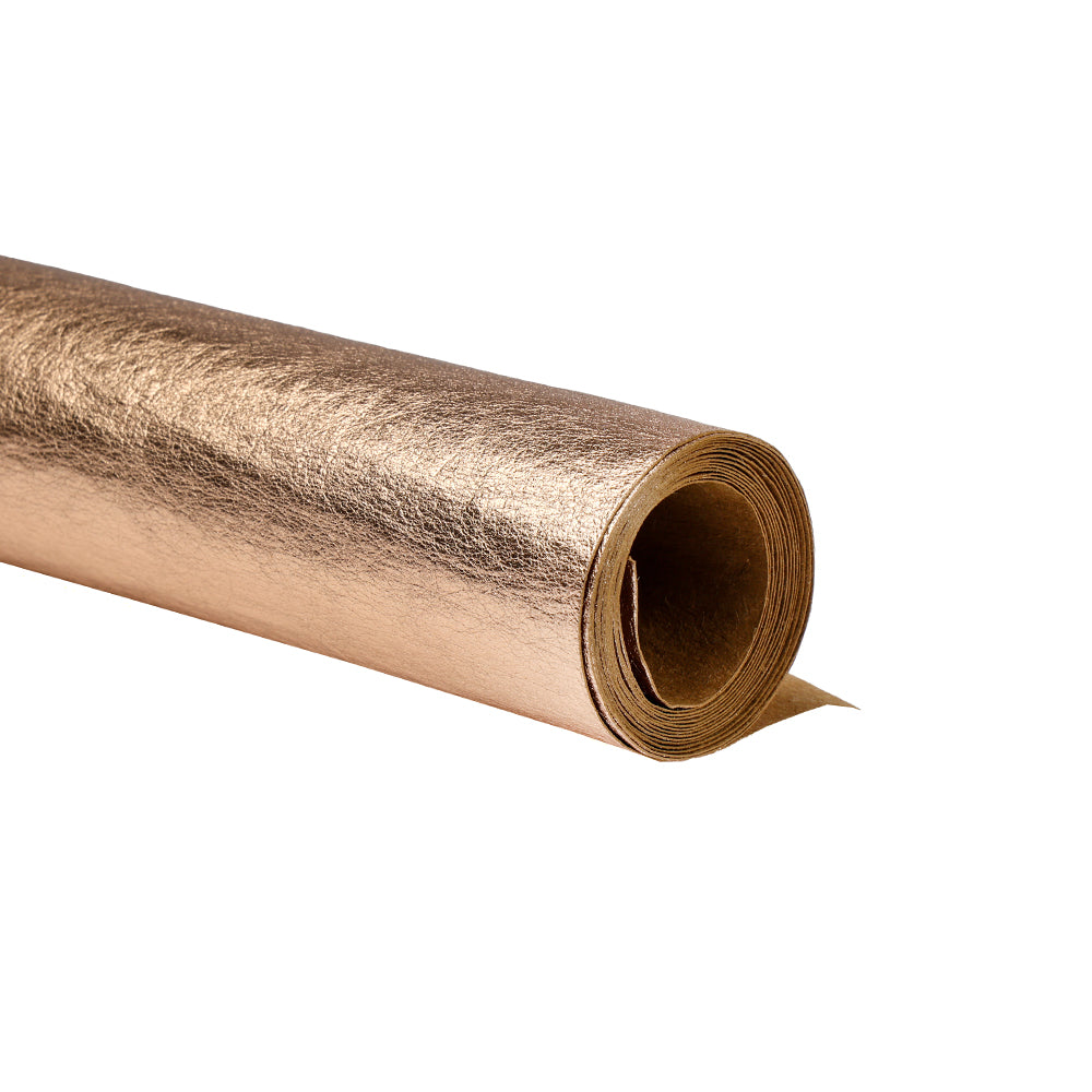 Eine Rolle seidenmatt glänzendes Papier in Metallic-Gold von Alexandra Renke, teilweise abgerollt auf weißem Hintergrund - perfekt für elegante Geschenkverpackungen.