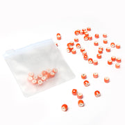 Kleine orangefarbene und weiße zylindrische Perlen von Alexandra Renke sind in einem halbtransparenten Kunststoffbeutel verstreut, der sich perfekt für die Herstellung von Schmuck oder anderen Perlenarbeiten eignet.