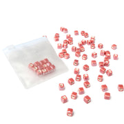 Kleine rosa Würfelperlen von Alexandra Renke, ideal zum Perlen basteln, sind neben einem transparenten Reißverschlussbeutel auf weißem Hintergrund verstreut. Perfekt für alle, die gerne Schmuck selbst machen.