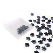 Ein durchsichtiger Beutel mit schwarzen Sternform Perlen von Alexandra Renke, mit zusätzlichen Perlen auf weißem Hintergrund - ideal für die Schmuckherstellung.