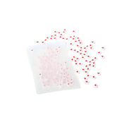 Ein ☆ Beutel, der mit kleinen runden Perlen gefüllt ist, die jeweils mit einem roten Herzmotiv verziert sind und auf einem weißen Hintergrund verstreut liegen - ideal für die Herstellung von Schmuck.