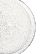 Eine durchsichtige Schale, gefüllt mit vielen kleinen, weißen, runden Mini-Glasperlen, von oben betrachtet vor weißem Hintergrund – ideal für Bastelprojekte oder zum Basteln von Schmuck.