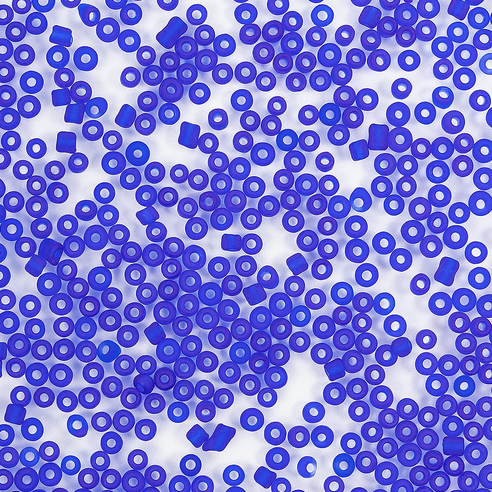 Verstreute blaue Plastikperlen und Mini-Glasperlen auf weißem Hintergrund, von oben betrachtet – ideal zum Schmuckbasteln oder für andere kreative Projekte.