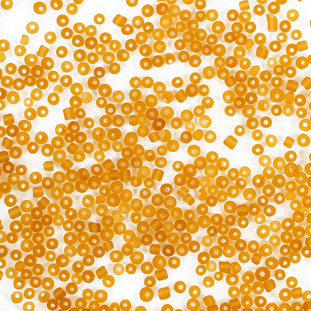 Kleine, runde, gelbe Nudelstückchen, die auf einem weißen Hintergrund verstreut sind, sehen aus wie Mini-Glasperlen und eignen sich perfekt als Bastelmaterial für alle, die gerne Schmuck basteln.