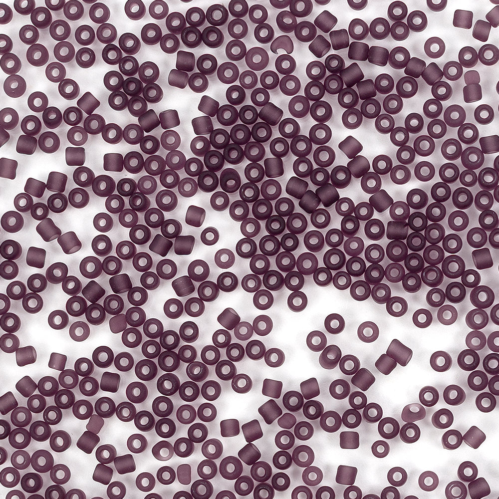 Zahlreiche kleine, runde, violette Bastelperlen mit Löchern sind über einen weißen Hintergrund verteilt – ideal für Projekte mit Mini-Glasperlen oder zum Basteln von Schmuck.