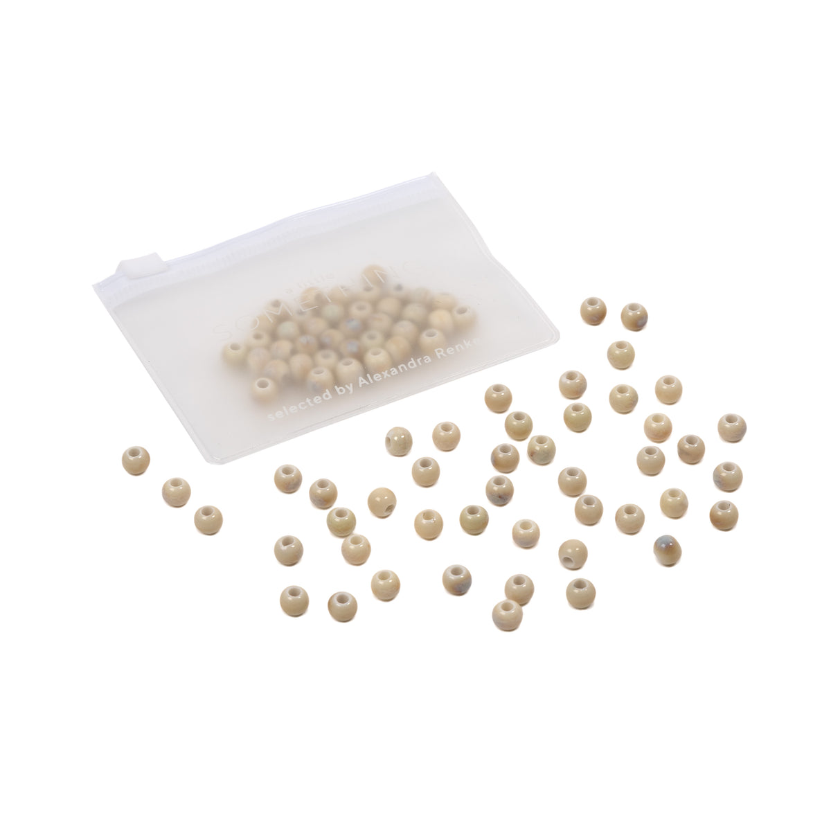 Kleine glasierte Keramikperlen sind auf einem weißen Hintergrund außerhalb eines teilweise offenen, durchsichtigen Plastikbeutels verstreut – ideal für alle, die selbst Schmuck basteln möchten.