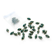 Kleine grüne Muschelperlen in Spiralform von Alexandra Renke sind auf weißem Hintergrund neben einem halbtransparenten Beutel mit Reißverschluss verstreut – ideal für DIY-Schmuckprojekte.