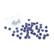 Kleine, blaue Keramikperlen mit Muscheloptik von Alexandra Renke sind neben einem durchsichtigen Beutel auf weißem Hintergrund verstreut.