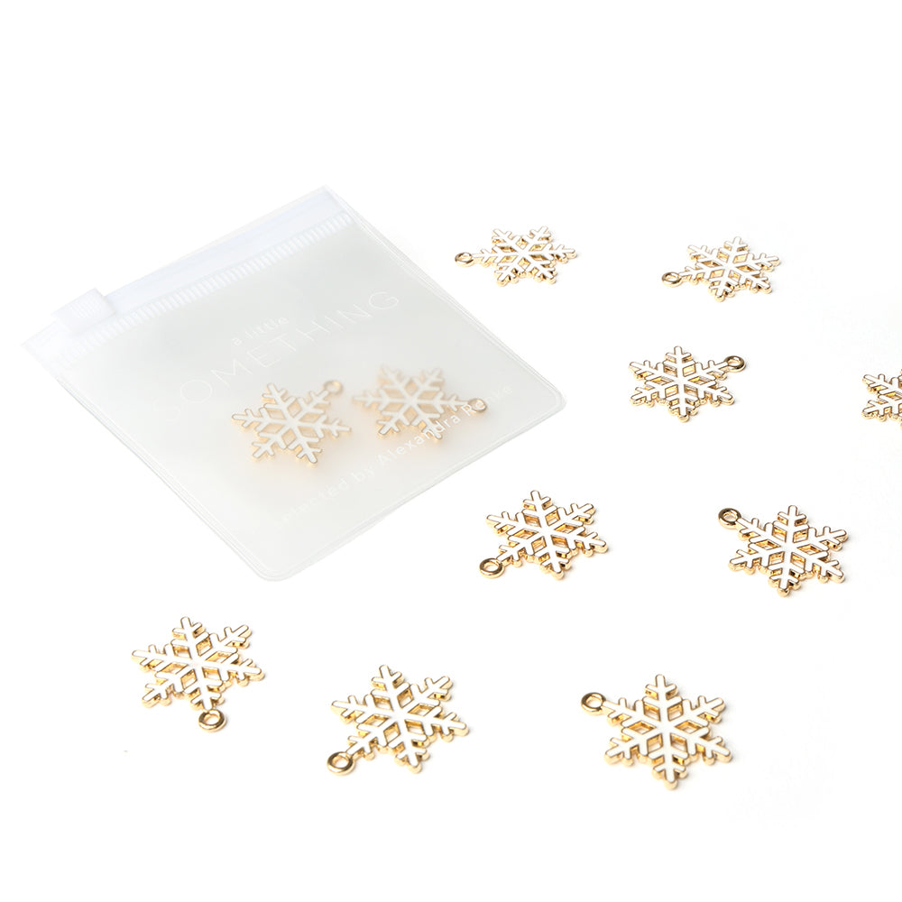 Die goldenen Schneeflocken-Anhänger von Alexandra Renke befinden sich in einem durchsichtigen Reißverschlussbeutel mit zwei Anhängern, perfekt, um Ihren Buchbindearbeiten oder Bastelprojekten Glanz zu verleihen.