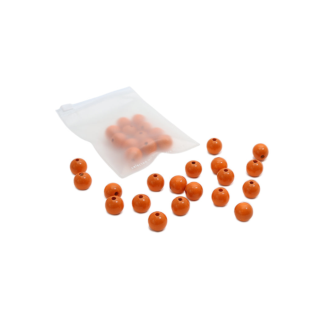 Kleine orangefarbene Perlen, verstreut neben einem halbtransparenten Reißverschlussbeutel, der weitere Alexandra Renke Holzperlen enthält – perfekt für Ihr nächstes Bastelprojekt.