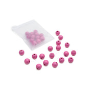 Aus einem kleinen weißen Säckchen fallen rosa, runde Holzperlen mit Löchern von Alexandra Renke auf eine weiße Fläche – perfekt für dein nächstes Bastelprojekt.