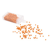 Kleine orangefarbene Rocailles-Perlen von Alexandra Renke rieseln aus einem durchsichtigen Plastikbehälter auf eine weiße Fläche und sorgen so für einen bezaubernden Vintage-Look.