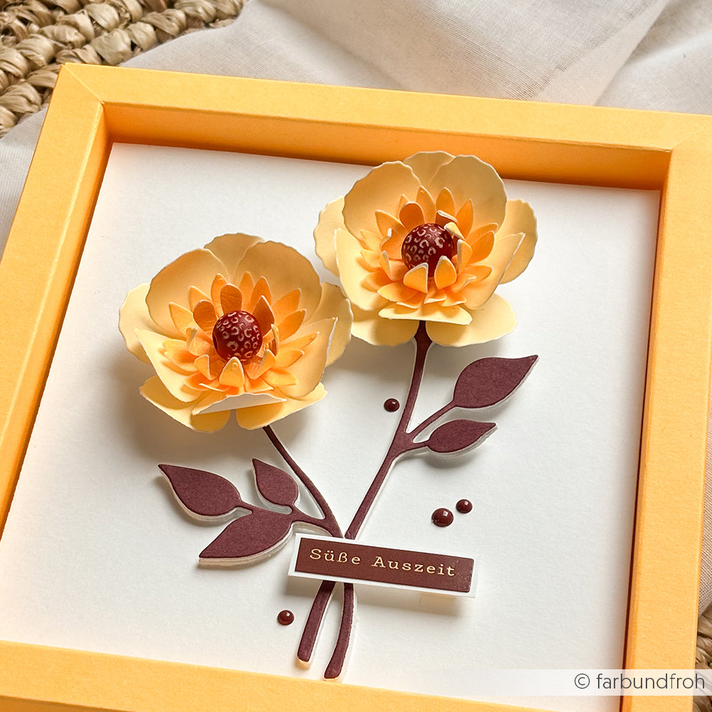 Gelbe 3D-Papierblumen mit kastanienbraunen Blättern in einem gelben Rahmen, mit der Aufschrift „Süße Auszeit“ auf weißem Hintergrund – die perfekte Inspiration für kreative Projekte oder als einzigartiger Akzent neben handgefertigten Holzperlen.