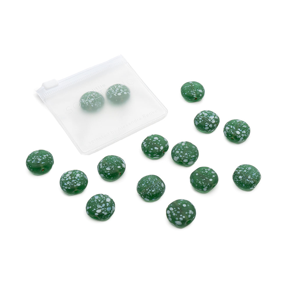 Grüne, runde Glasperlen mit matter Oberfläche der Marke Alexandra Renke sind auf einem weißen Hintergrund verstreut und liegen neben einem durchsichtigen Täschchen mit Reißverschluss – perfekt geeignet für kreative DIY-Projekte.