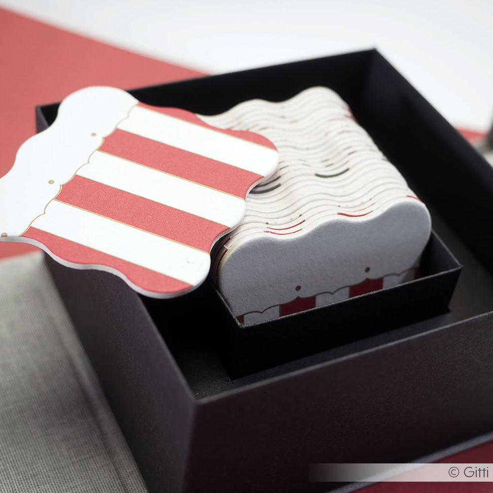 Die rot-weiß gestreiften Notizkarten in Form von Popcornschachteln von Alexandra Renke sind in einer schwarzen Geschenkbox gestapelt.