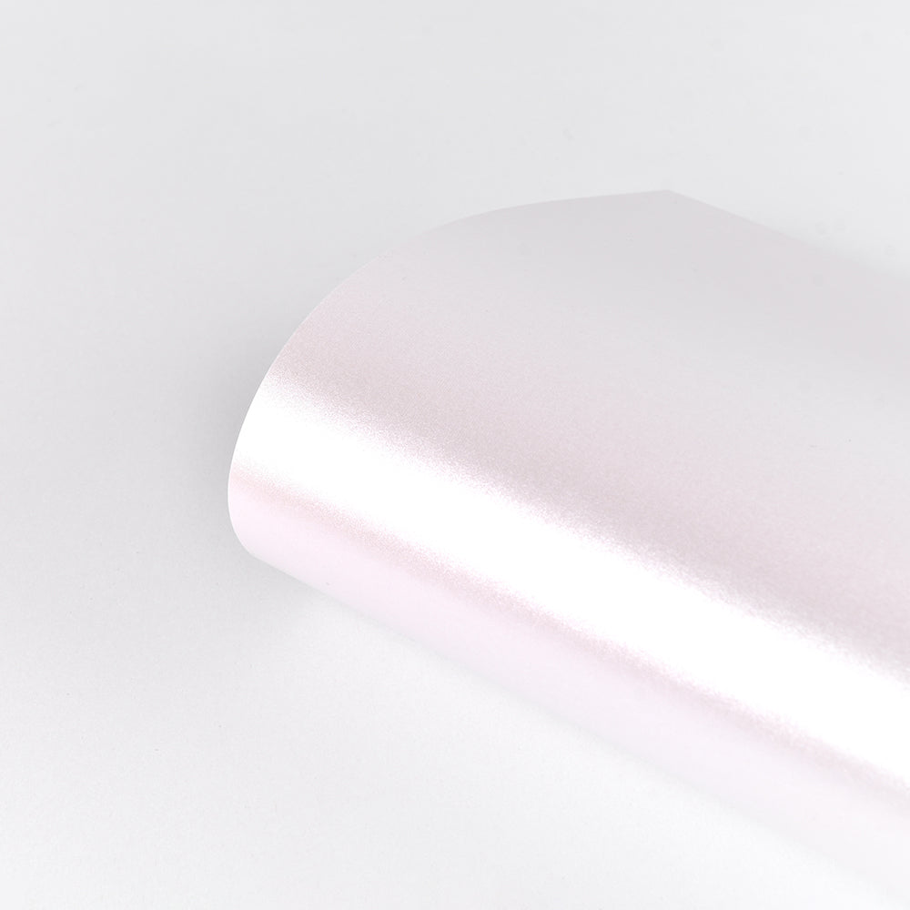 Ein Bogen ☆ Schimmer Effekt Papier, glänzend und hellrosa (310 g/m²), für Karten, teilweise gewalzt auf einer weißen Oberfläche.