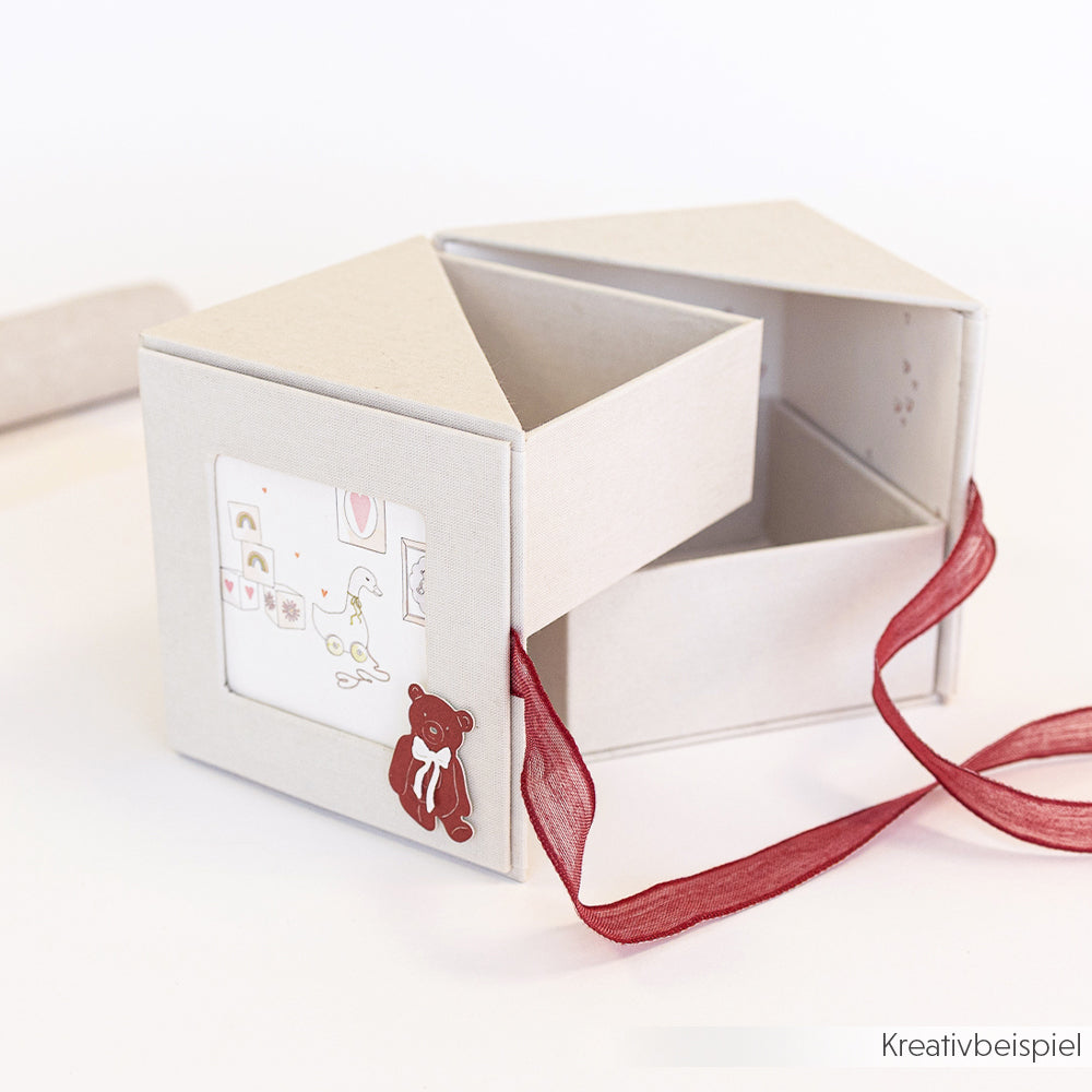 Die dreieckige Geschenkbox von Alexandra Renke ist mit einer roten Schleife und einem Teddybär-Aufkleber verziert und lässt sich öffnen, um Fächer zu öffnen - ideal als einzigartiges PAPPKit oder Fotobox für besondere Anlässe.