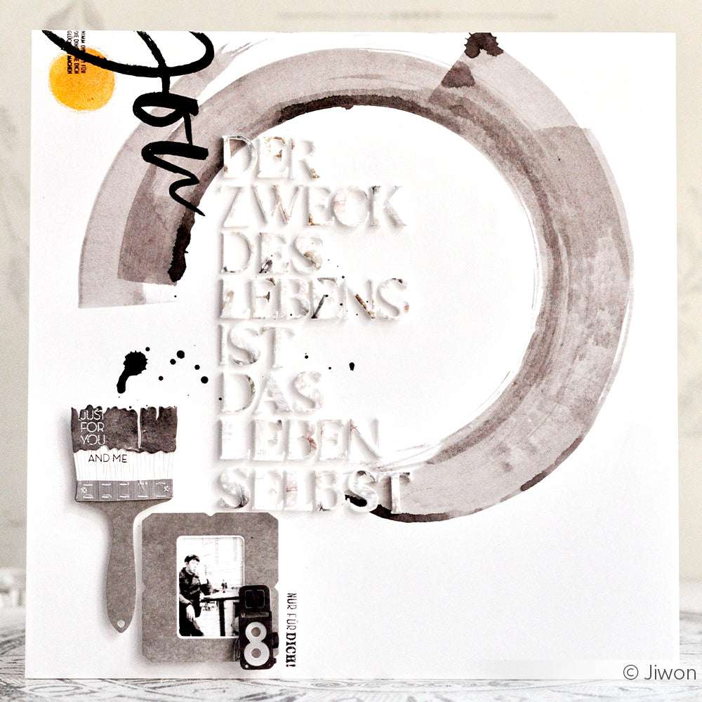 Ein weißes Papier von Alexandra Renke mit deutschem Text, abstrakter Kunst, einem Pinsel und einem Schwarz-Weiß-Foto - ideal für kreative Projekte mit Designpapieren oder zum Aufpeppen mit den Motivstanze Kamera Minis.