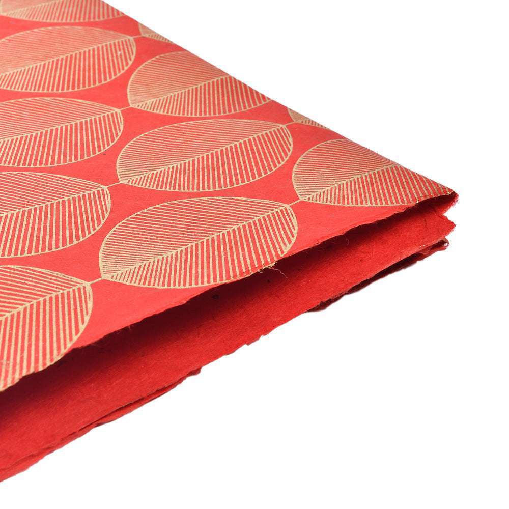 Rotes dekoratives Nepalpapier mit Blattgoldmustern, ideal zum Verpacken von Geschenken oder zum Buchbinden, auf weißem Hintergrund gestapelt.
