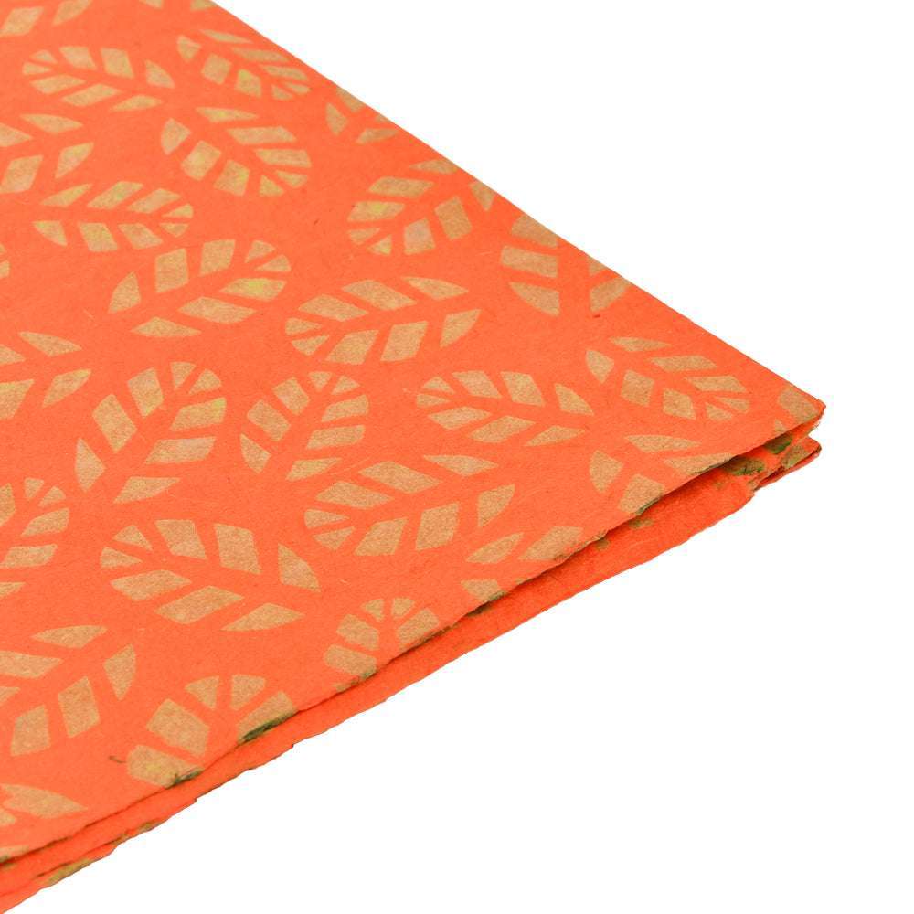 ☆ Orangefarbenes Nepalpapier mit Blattgoldmuster, ideal für Buchbinden oder Geschenke Verpacken, wird an der Ecke gefaltet auf weißem Hintergrund dargestellt.