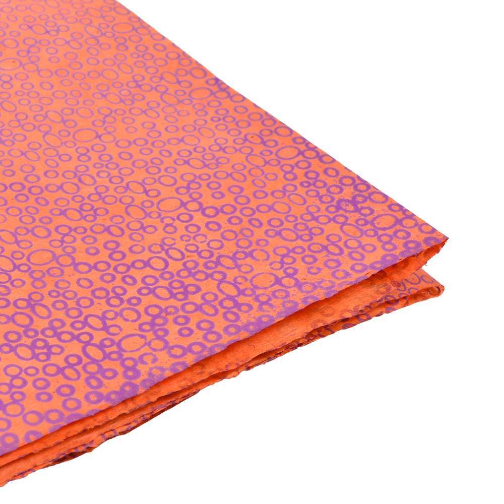 Gefalteter orangefarbener Stoff mit einem Kreismuster Orange von ☆ auf weißem Hintergrund - ideal für Geschenke Verpacken oder um Ihren Bastelarbeiten ein von Nepalpapier inspiriertes Flair zu verleihen.