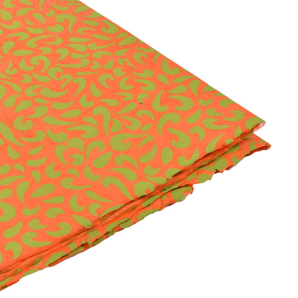 Leuchtend orangefarbener Stoff mit grünem, abstraktem Blattmuster von ☆ auf weißem Hintergrund - ideal zum Einpacken von Geschenken oder als kreative Inspiration für Buchbinderarbeiten mit Nepalpapier.