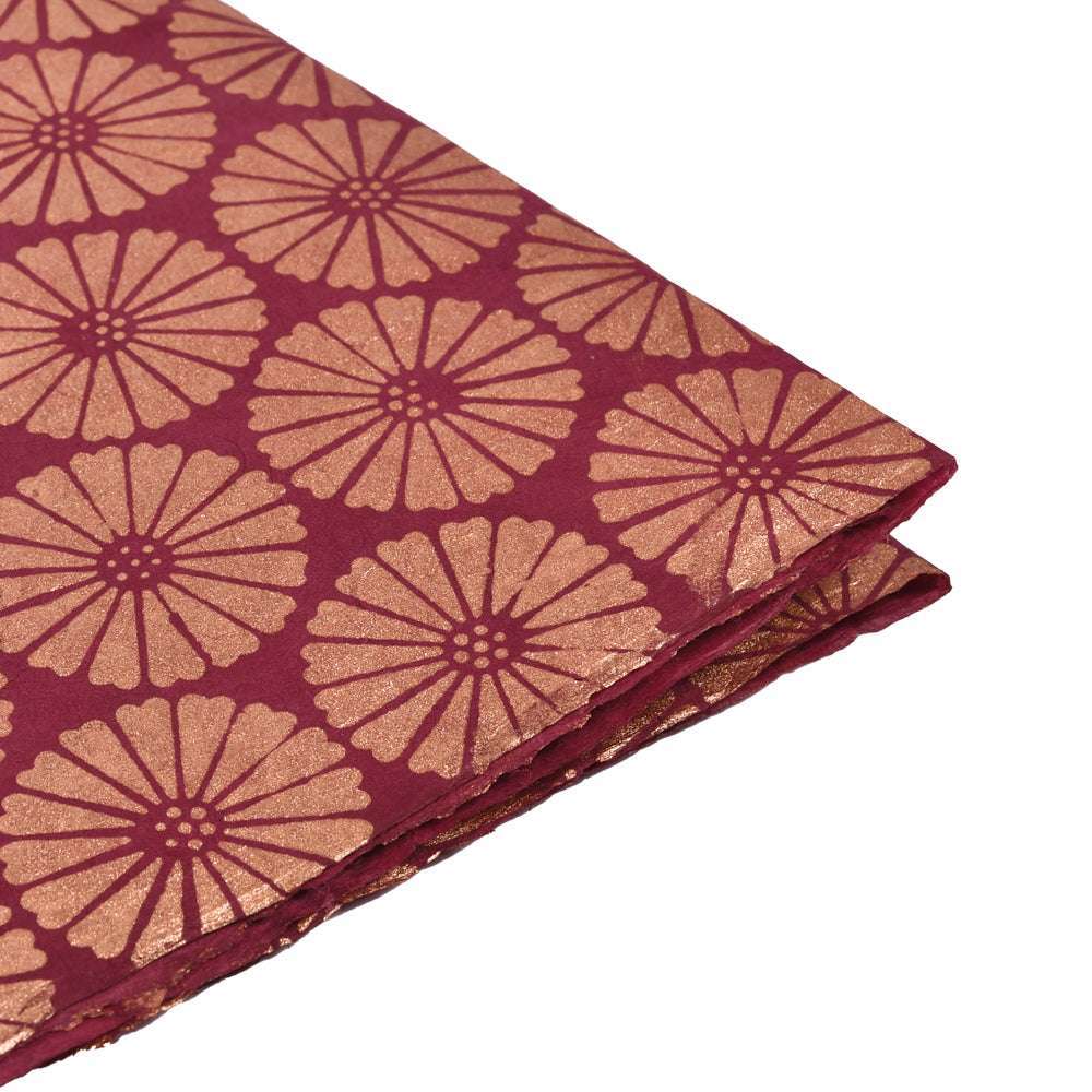 Kastanienbrauner Stoff mit goldenen, geometrischen Blumenmustern, ideal zum Verpacken von Geschenken oder zum Veredeln von Buchbindearbeiten.