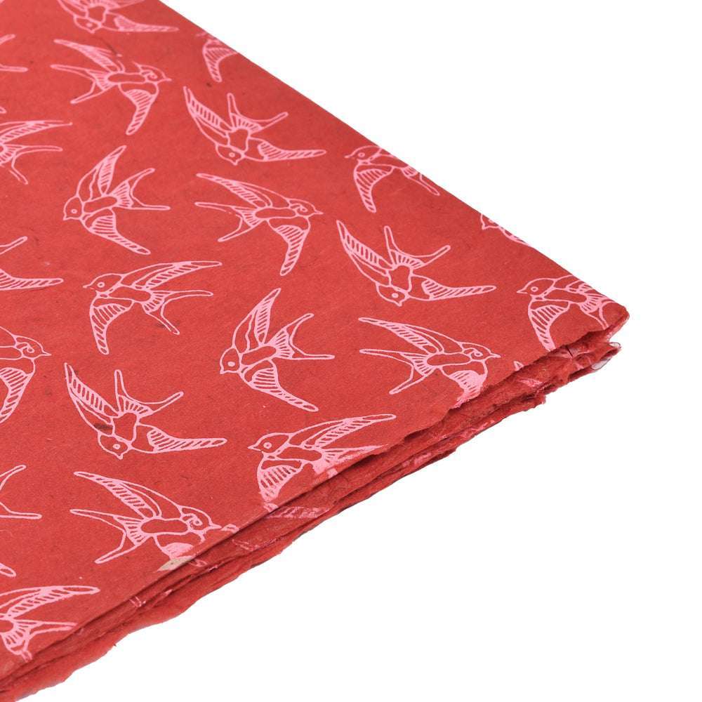 Roter Stoff mit rosafarbenem Vogelmuster von ☆, sauber gefaltet auf weißem Hintergrund - ideal zum Einpacken von Geschenken oder zum Veredeln Ihrer buchbinderischen Kreationen.