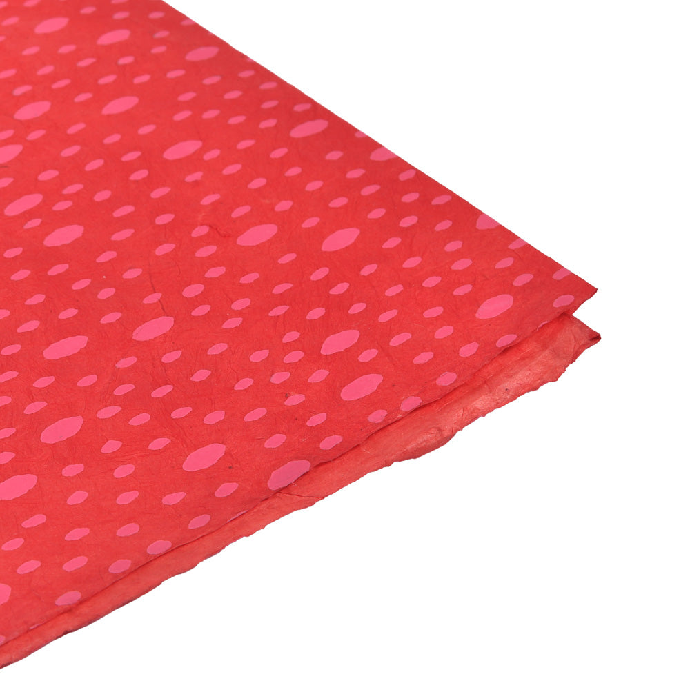 Rotes Nepalpapier von ☆ mit unregelmäßigen rosa Tupfen, gewinkelt auf weißem Hintergrund - ideal zum Buchbinden oder Verpacken stilvoller Geschenke.