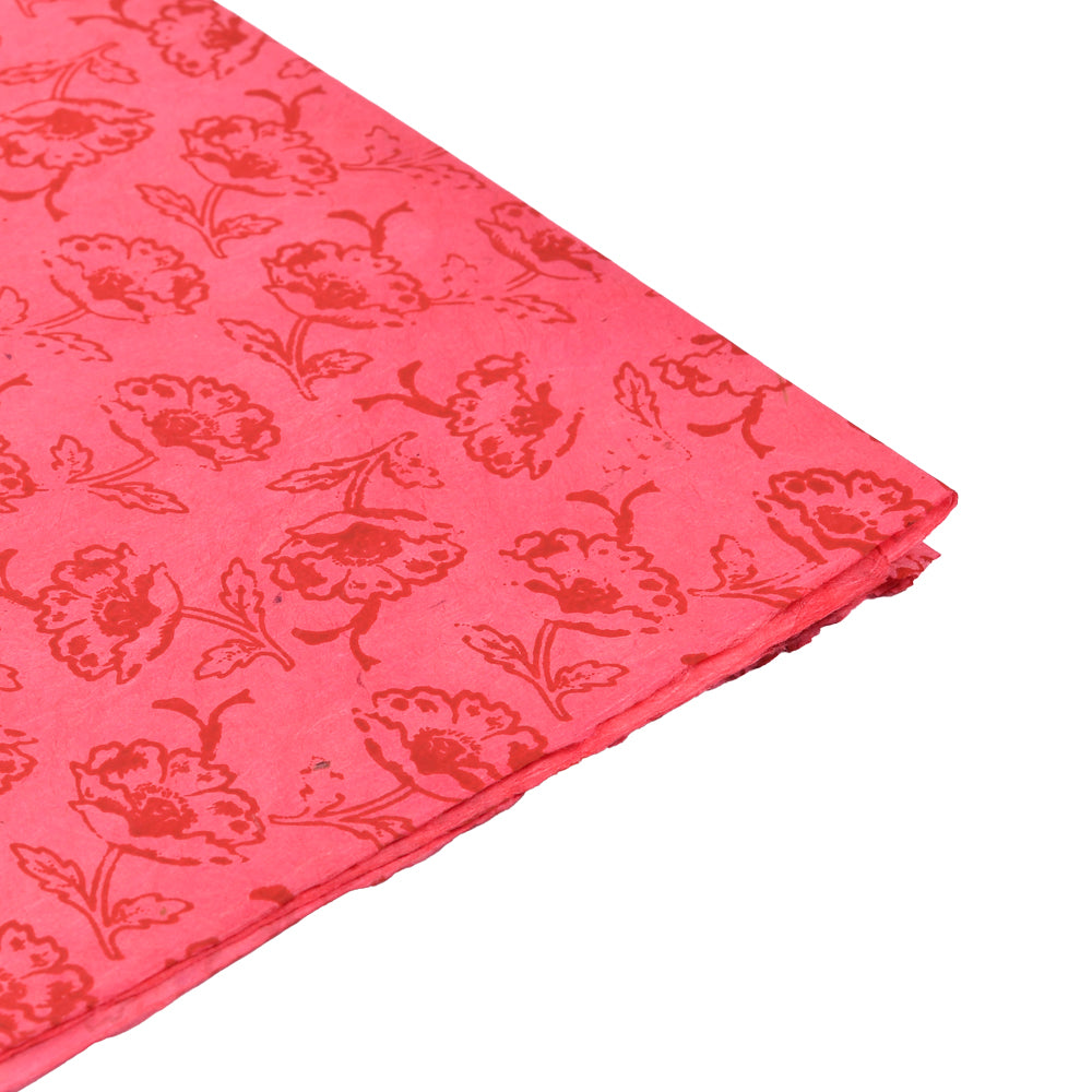 Rosafarbener Stoff mit rotem Blumenmuster von ☆, sauber gefaltet auf weißem Hintergrund - ideal zum Verpacken von Geschenken oder in Kombination mit umweltfreundlichem Papier für einen nachhaltigen Touch.