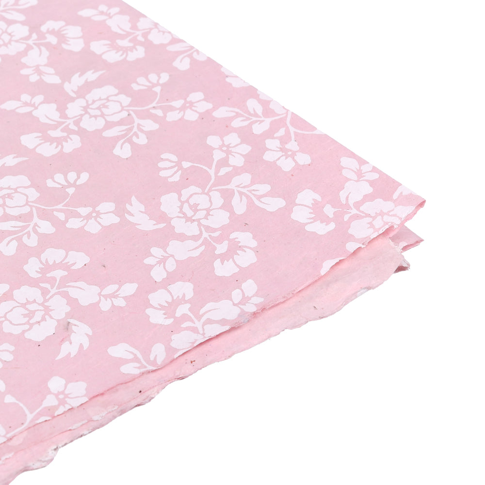 Rosa Nepalpapier mit weißen Blumenmustern, leicht strukturiert und unebenen Rändern - ideal zum Buchbinden oder Verpacken von Geschenken. Abgebildet auf weißem Hintergrund.