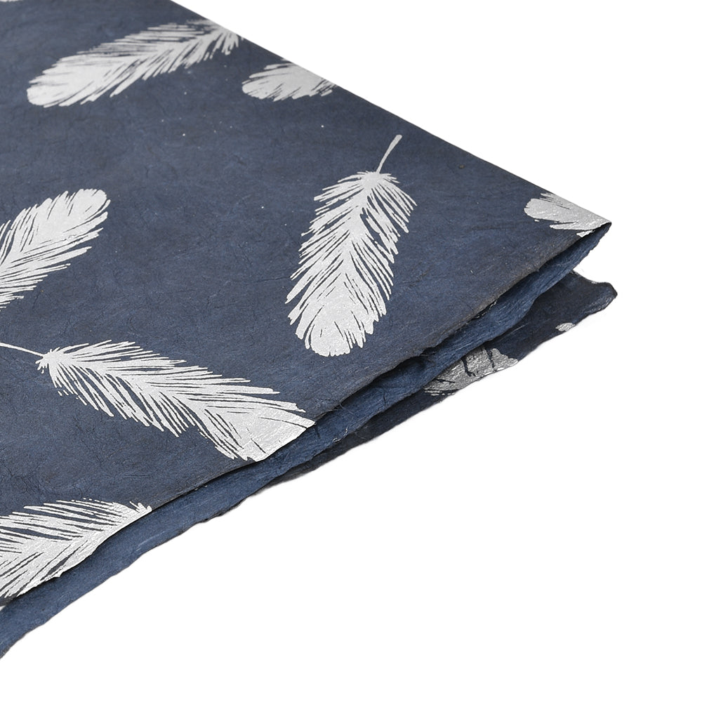 Marineblaues Nepalpapier mit weißem Federdruck, ideal für Geschenkverpackungen oder Bucheinbände, an der Ecke gefaltet auf weißem Hintergrund.