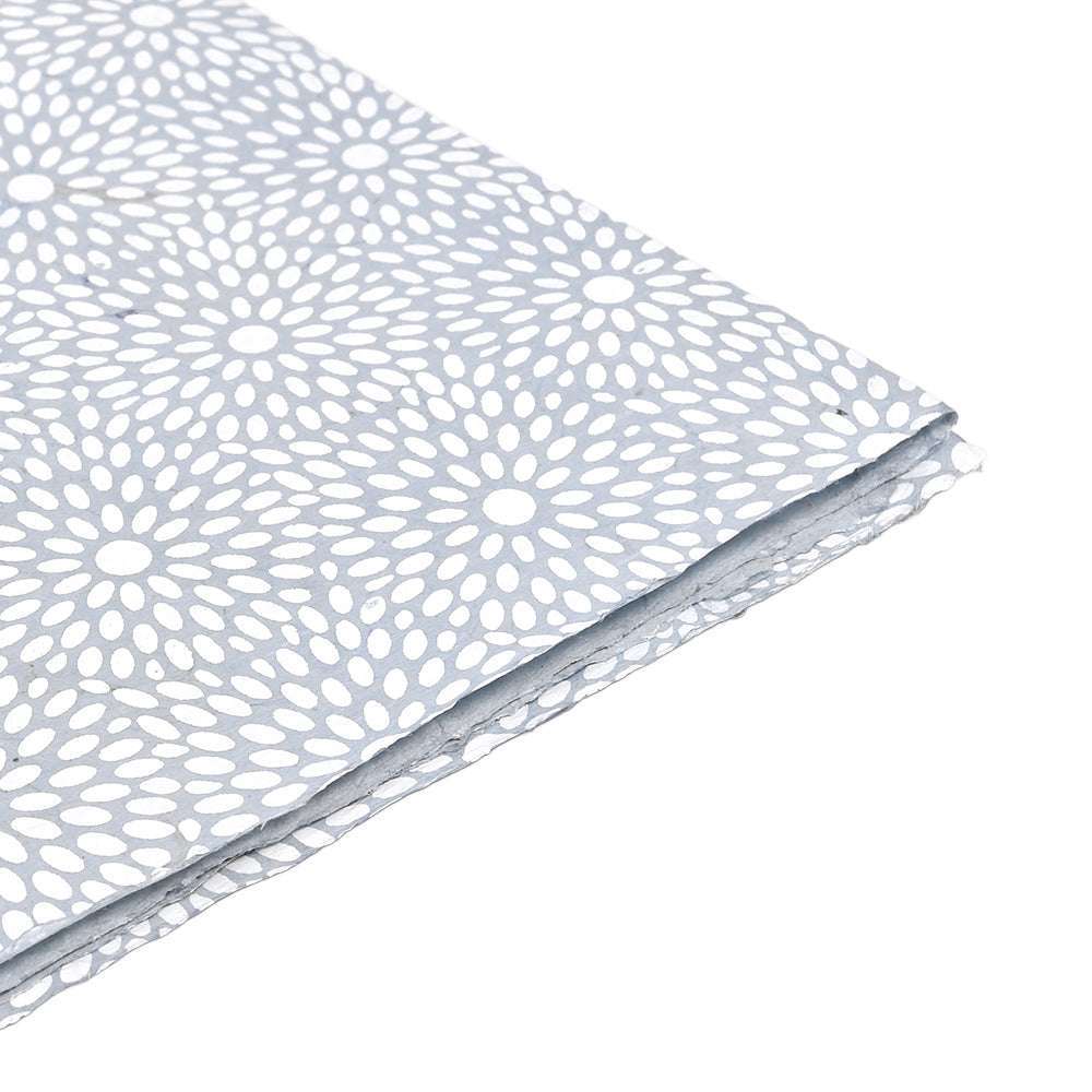 ☆ gefaltetes Nepalpapier mit weißem Blumenmuster auf hellgrauem Hintergrund, dargestellt auf einer weißen Fläche.