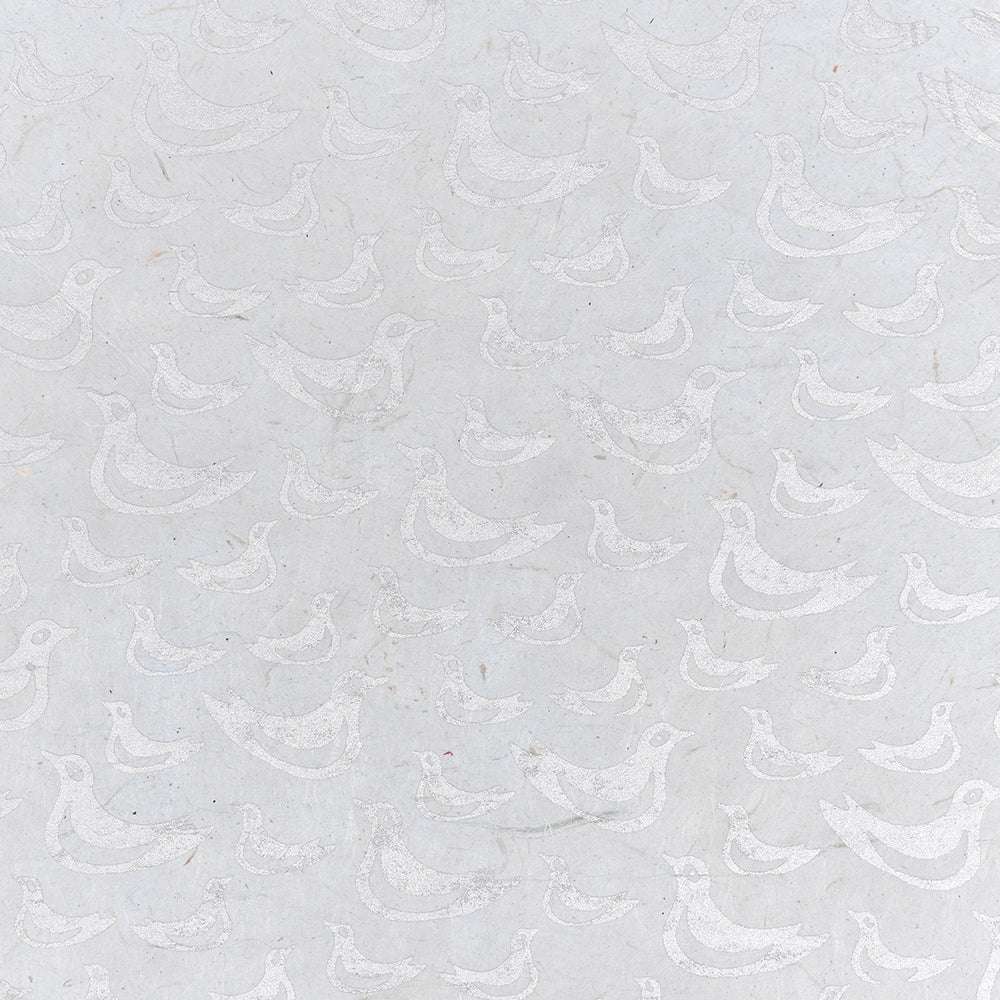 Hellgraues Nepalpapier von ☆ zeigt ein sich wiederholendes Muster aus einfachen, weiß umrandeten Vögeln, die in verschiedene Richtungen zeigen - ideal für Geschenkverpackungen oder Buchbindearbeiten.