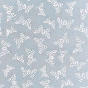 Verstreute weiße Mottenillustrationen auf hellblauem Nepalpapier von ☆, perfekt für Bastelarbeiten oder Geschenkverpackungen.