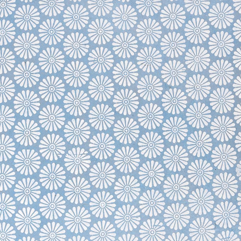 Weiße gänseblümchenartige Blüten wiederholen sich auf hellblauem Hintergrund - ideal für Geschenke Verpacken oder Buchbinden mit schönem Nepalpapier von ☆.
