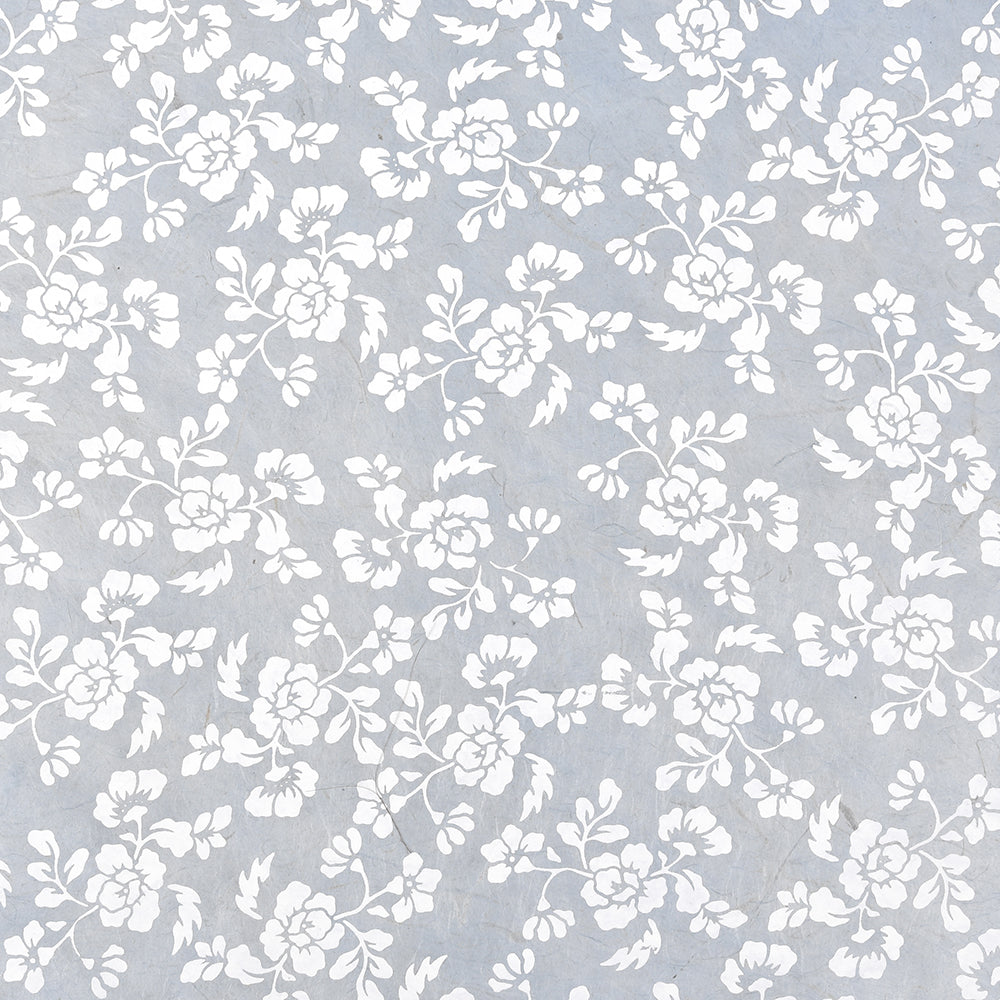 Zarte weiße Blumenmuster auf hellblauem, strukturiertem Hintergrund, inspiriert von Nepalpapier. Elegante Zweige und Blätter sorgen für einen raffinierten Look - ideal für Geschenke oder Bastelarbeiten. Marke: ☆.