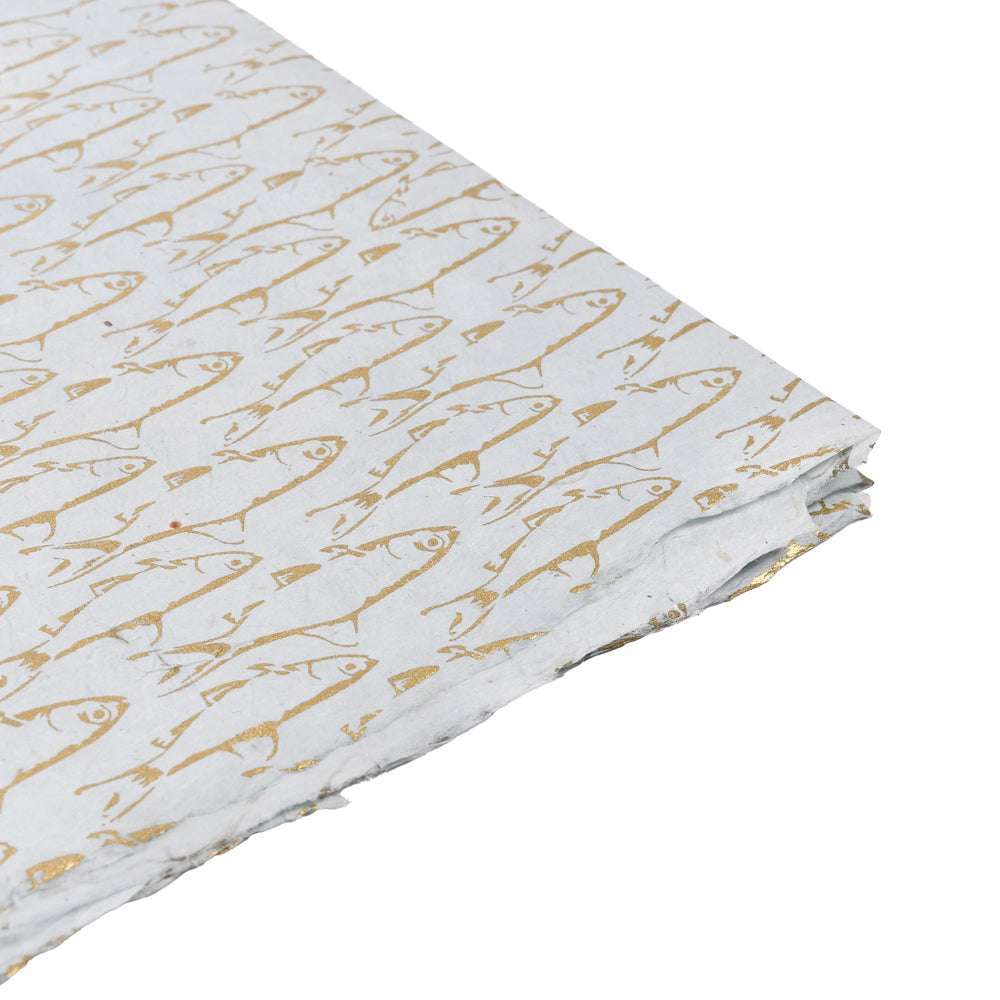 Weißes handgefertigtes Nepalpapier mit einem sich wiederholenden goldenen Fischmuster - ideal zum Einpacken von Geschenken oder für kreative Projekte.
