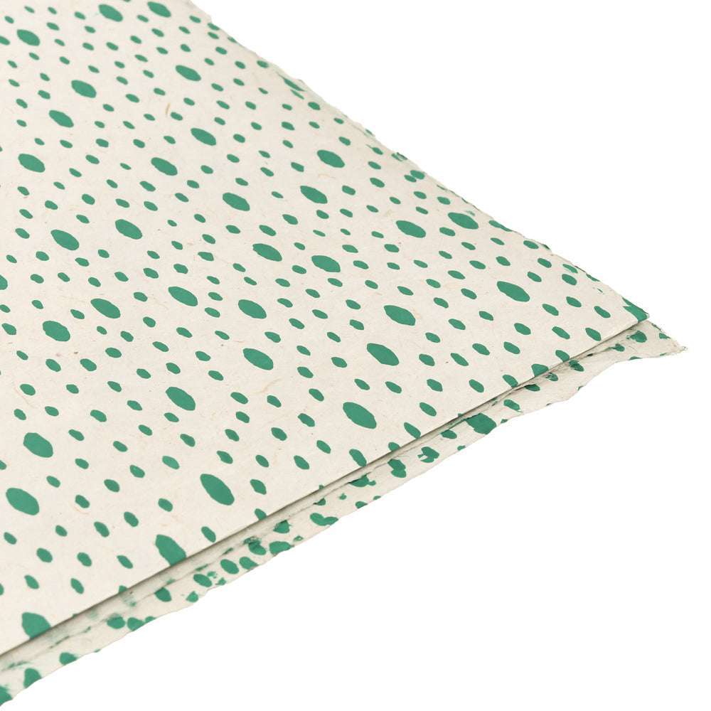 Zwei Bögen cremefarbenes ☆ Nepalpapier mit unregelmäßigen grünen Punkten und Tupfen - perfekt für kreative Geschenkverpackungen oder um Buchbindungsprojekten ein einzigartiges Flair zu verleihen.