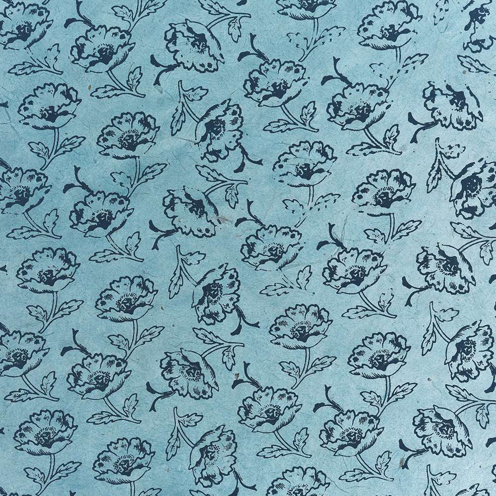☆ Blaues Blumenmuster mit dunkelblauen Blüten und Blättern auf einem hellblauen, strukturierten Nepalpapier-Hintergrund, ideal für Buchbinden oder Geschenkverpackungen.