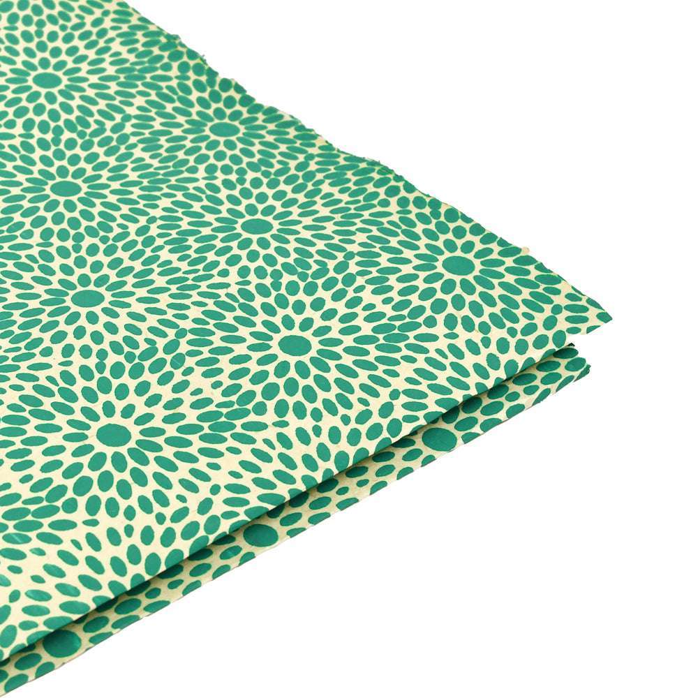 Gefaltetes grün- und cremefarben gemustertes Nepalpapier von ☆, mit einem kreisförmigen Blumenmuster auf weißem Hintergrund - ideal für Buchbinden oder Geschenkverpackungen.