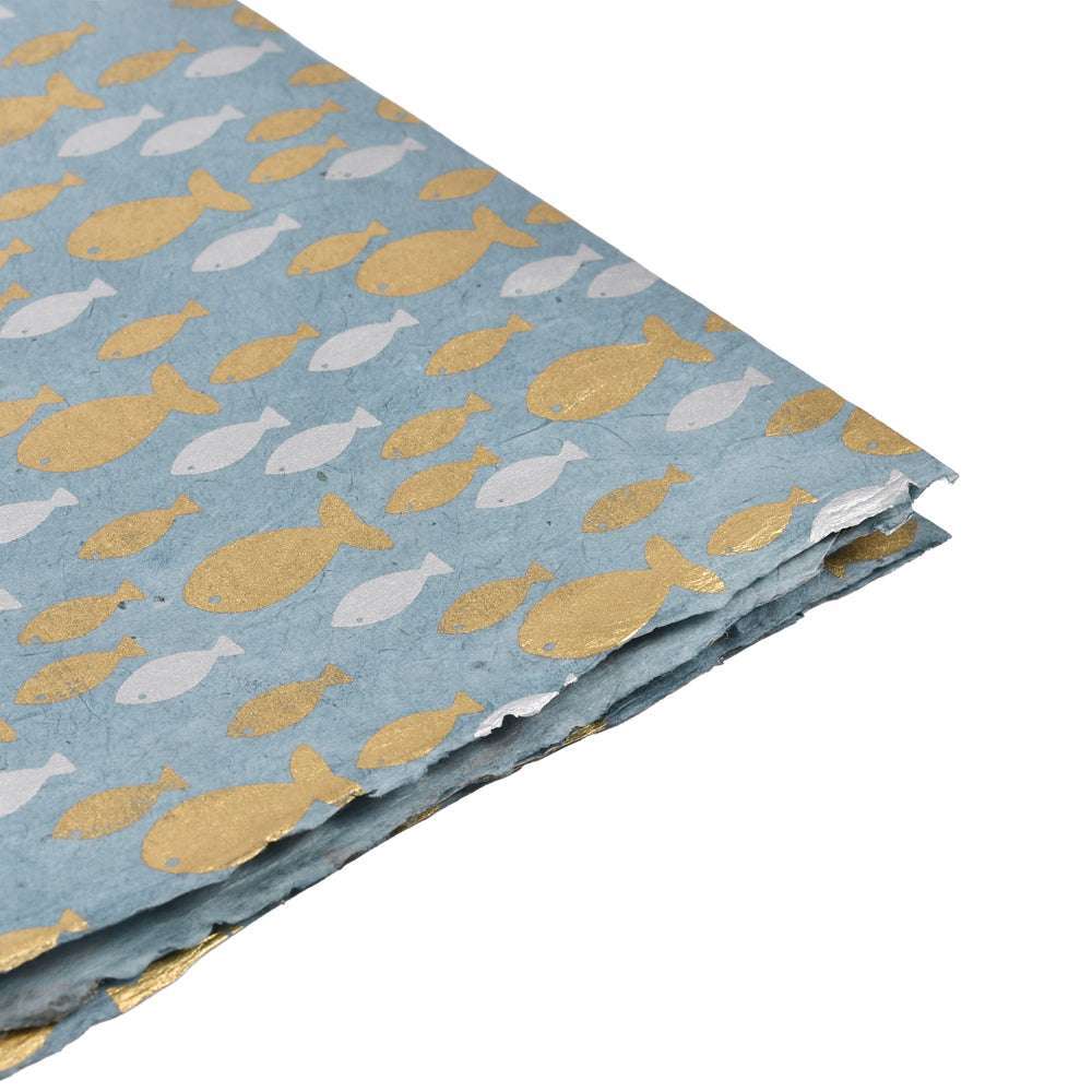 Das blau-goldene Nepalpapier zeigt ein sich wiederholendes Fischmuster in verschiedenen Größen - ideal zum Einpacken von Geschenken oder um Ihren buchbinderischen Projekten ein unverwechselbares Flair zu verleihen.