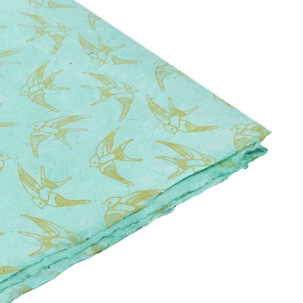 Hellblaues Nepalpapier von ☆ mit gelben Vogeldrucken und rauem Rand, schräg gezeigt - perfekt für Buchbinden oder Geschenke Verpacken.