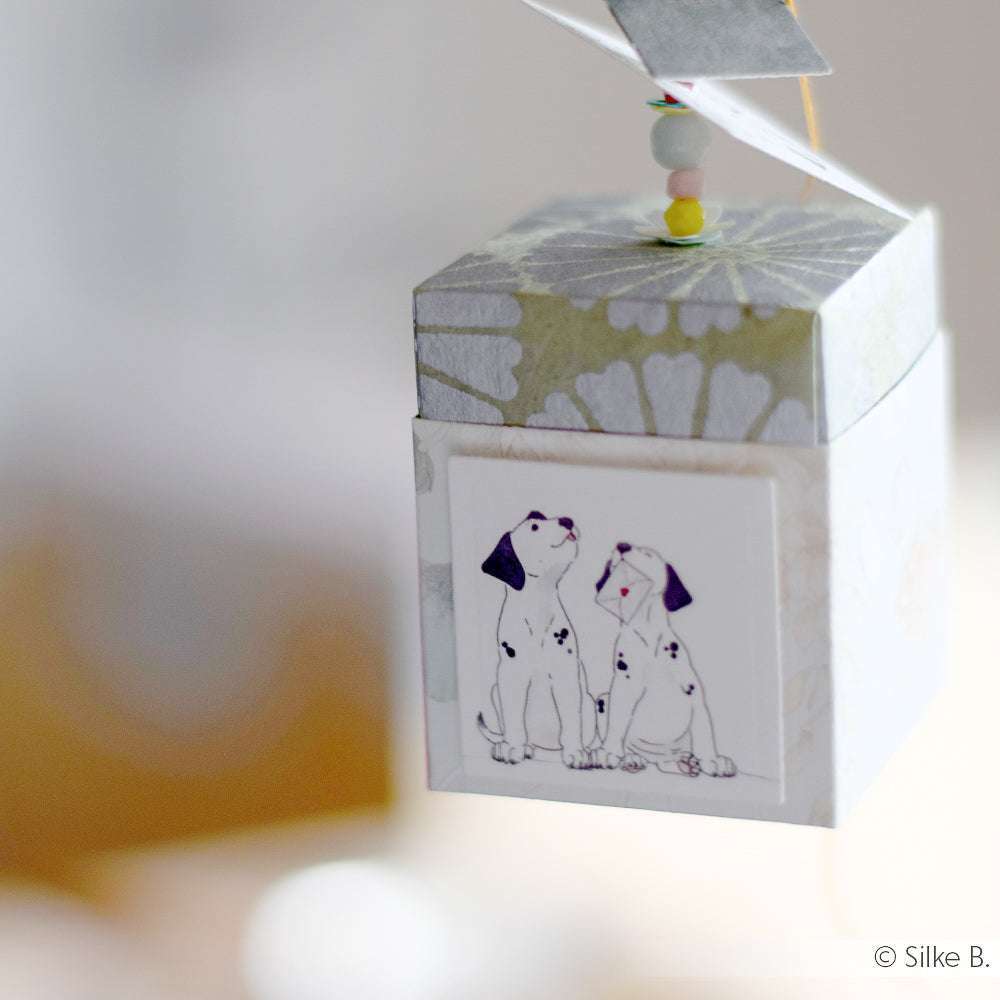 Dekorative Schachtel von ☆ aus Nepalpapier, mit zwei Dalmatiner-Illustrationen, an einer Perlenschnur hängend - ideal für Buchbinden oder liebevoll Geschenke Verpacken.